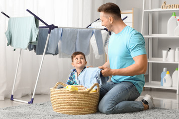 Sticker - Man and his little son doing laundry at home