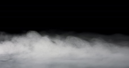 Wall Mural - heavy fog passing across a black background.