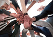 © ASDF - group of diverse young people folding their hands in a circle