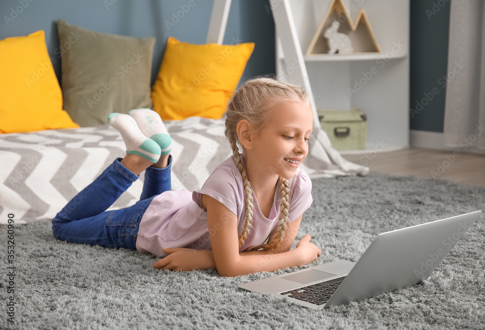 Cute little girl with laptop at home. Concept of online education