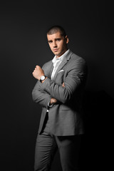 Poster - Handsome young man in elegant suit on dark background