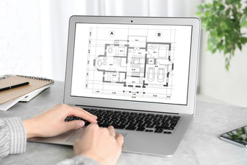 Canvas Print - Architect making project of house on laptop in office, closeup