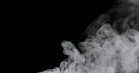 Wall Mural - cloud of thick white smoke pouring in and filling the black background.