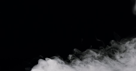 Wall Mural - wispy smoke rolling along the bottom of the frame, against a black background.