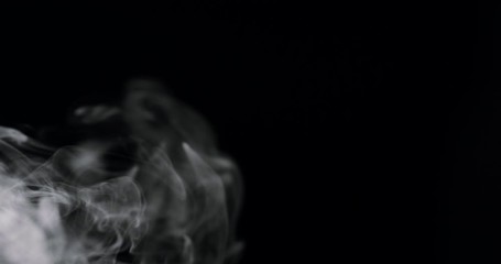 Wall Mural - swirling white cloud of smoke against a black