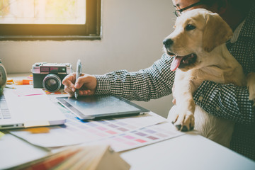 Fototapete - Designers and designers work at home by carrying puppies in their arms.