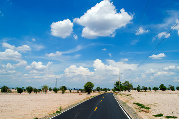 asphalt road electronic wire and white sand on hill with blue sky background