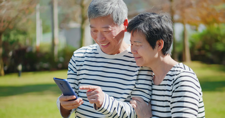 Wall Mural - Asian elder couple use mobile