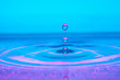 water drop splash on color gradient blue violet surface macro