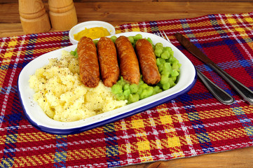 Wall Mural - Sausage and mashed potato meal with mushy peas in a metal enamel dish