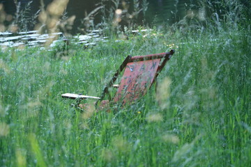 Poster - Liegestühle stehen im Gras am Fluss