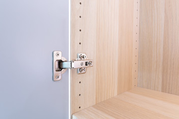 Polished Stainless door hinge on a cabinet door for interior design.