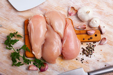 Preparation Of Raw Chicken Breast Fillet With Parsley And Garlic On Cutting Board