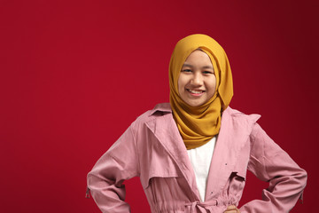 Wall Mural - Portrait of young happy confident muslim teenage girl wearing hijab looking at camera and smiling cheerfully