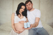 © Алина Троева - Pregnancy and people concept - happy man hugging his beautiful pregnant wife at home. Future parents waiting unborn baby. Love, relationship, birth, happy family concept - young lovely married couple