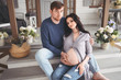 © Алина Троева - Pregnancy and people concept - happy man hugging his beautiful pregnant wife at home. Future parents waiting unborn baby. Love, relationship, birth, happy family concept - young lovely married couple