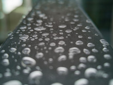 Small Water Drops On Gray Steel Barrier