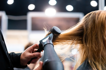 Wall Mural - Drying hair with hair dryer and round brush close up