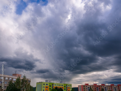 Fotomural Dramatic heavy and dark rain clouds over houses
