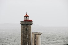 Beautiful View Of The Lighthouse With The Sea On The Background On A Foggy Day