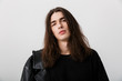 © Drobot Dean - Portrait of handsome young man with long hair wearing black lather jacket posing and looking at camera