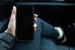 © Sarah Rypma - Overhead view a smart phone in hand inside a car