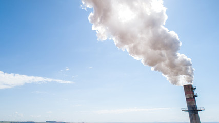 Air pollution from power plant chimney. Dirty smoke on the sky, ecology problems.