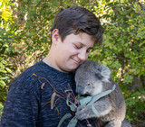 A Boy Cuddling a Koala Pup
