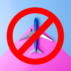 Airplane in red round ban sign, epidemic, state quarantine, stop symbol on blue pink background