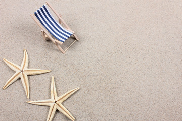 An empty chaise longue and two starfish. Summer 2020 vacation and travel background. Top view. Copy space..