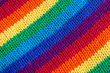 A knitted wool fabric in the colors of the rainbow. Fun background. Diagonal stripes.