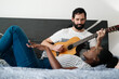 © Diego Cervo - Man Playing Guitar And Woman Singing Song In Bedroom
