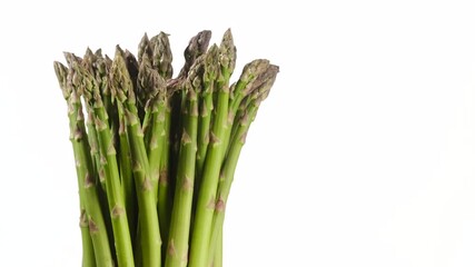 Wall Mural - asparagus green bunch on white background rotating. place for text