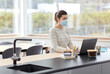 © Syda Productions - quarantine, remote job and pandemic concept - woman wearing face protective medical mask for protection from virus disease with laptop computer and notebook working at home office