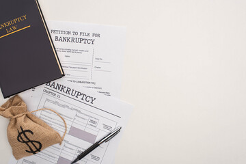 Wall Mural - top view of bankruptcy papers, law book, money bag on white background