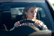 © DimaBerlin - Woman drives her car for the first time, tries to avoid a car accident, is very nervous and scared, worries, clings tightly to the wheel. Inexperienced driver in stress and confusion after an accident
