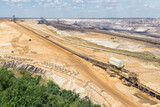Fototapeta  - Brown coal open pit landscape with digging excavators in Germany