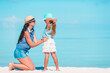 © travnikovstudio - Beautiful mother and daughter at Caribbean beach enjoying summer vacation.
