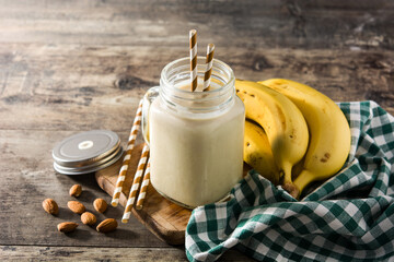 Poster - Banana smoothie with almond in jar on wooden table