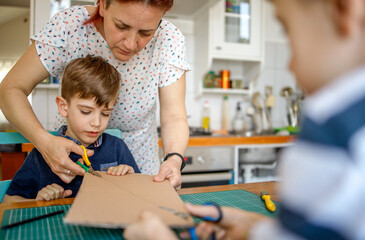 Canvas Print - Mom and kids making a cardboard dinosaur costume	
