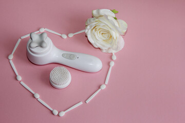 Canvas Print - a white massager with face lift attachments and a heart of white shadow applicators and a rose on a pink background