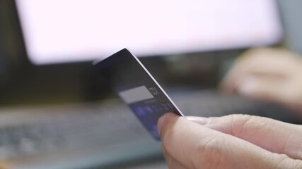Poster - close up Shallow focus hand hold Credit Card and other hand key in keyboard. Background for E-commerce and online shopping concept.