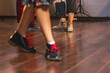 © tsuguliev - Dancing shoes of young couple dance retro jazz swing dances on a ballroom club wooden floor, close up view of shoes, female and male, dance lessons