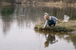 © olgalisa88 - Little girl in rubber boots catches and feeds fish on the river in a jar