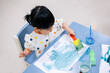 Asian toddler girl is painting water color. toddler activity at home.
