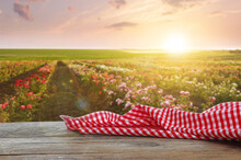Picnic Wooden Table With Checkered Red Napkin And Beautiful Roses On Background