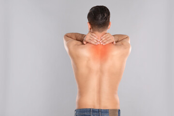 Canvas Print - Man suffering from pain in neck on light grey background