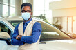 © yurakrasil - Handsome man in medical mask is standing near his new car and smiling