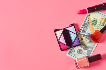 Various cosmetics accessories and banknote of 100 dollars on pink background. Concept of cost of beauty