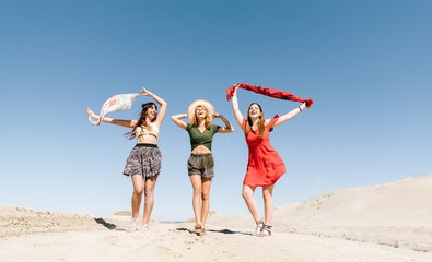 Wall Mural - Happy three women having fun walking on the beach. Young people at holiday vacation at summer enjoy freedom